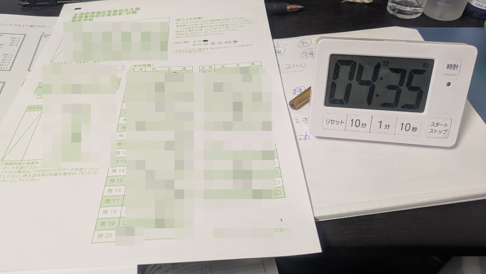 ユーキャン医療事務試験の解答用紙を記入し残り時間を確認している様子